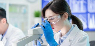 Female scientist examining a sample under a microscope in a laboratory