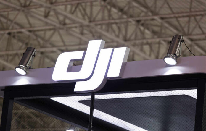 Illuminated DJI logo at an exhibition booth