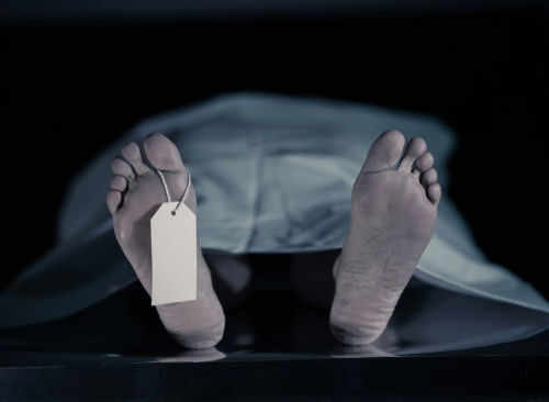 dead-body1552104335jpg Feet with tag under white sheet in morgue