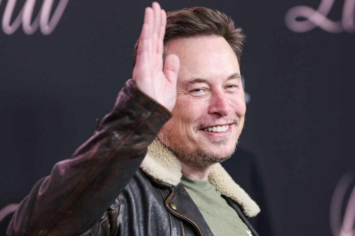 elon-musk700389456jpg Man smiling while raising his right hand wearing jacket