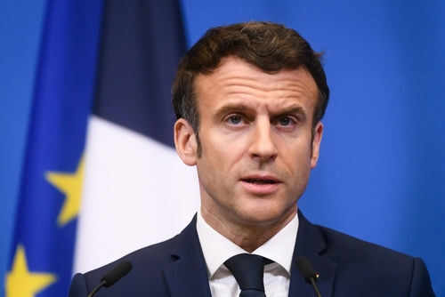 emmanuel-macron2139121517jpg Man speaking at press conference with flags behind