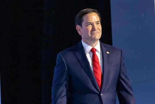 Man in suit and red tie on stage