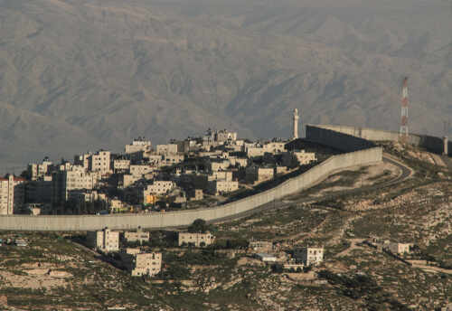 shutterstock_1059368186.jpg A view of a residential area bordered by a separation barrier in a mountainous region