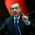 A politician delivering a speech with an emphatic gesture