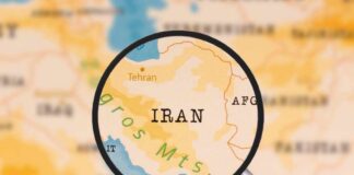 A magnifying glass focusing on the country Iran on a map