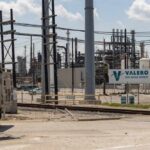 Valero Port Arthur Refinery with industrial structures and a truck in the foreground
