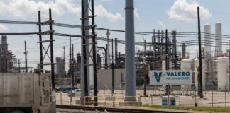 Valero Port Arthur Refinery with industrial structures and a truck in the foreground