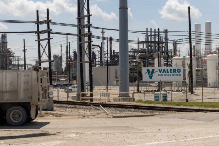 shutterstock_2416518109.jpg Valero Port Arthur Refinery with industrial structures and a truck in the foreground