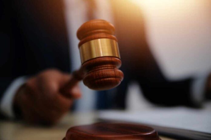 shutterstock_2555143941.jpg A gavel being struck on a desk in a courtroom setting