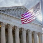 The Supreme Court building with an American flag waving in front