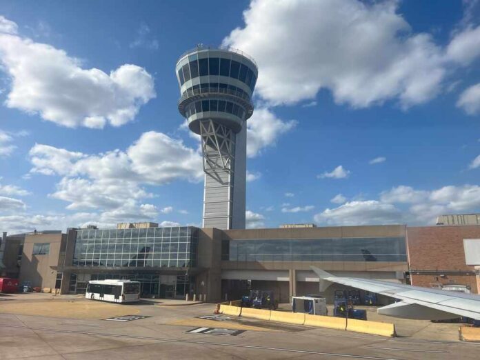 shutterstock_2688609979.jpg View of an airport control tower and terminal from an airplane window