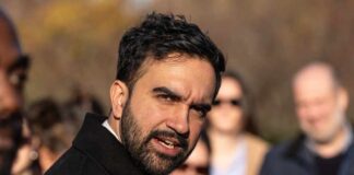 A man speaking passionately to a group of people outdoors