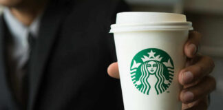 Person holding a Starbucks coffee cup.