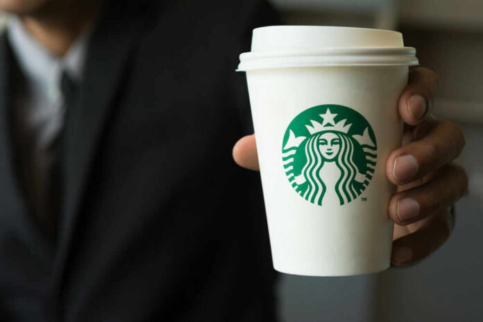 starbucksid717683842jpg Person holding a Starbucks coffee cup.