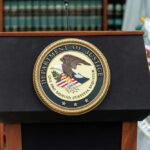 U.S. Department of Justice podium with seal.