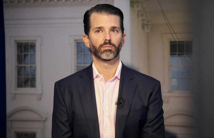 Man in a suit standing indoors with windows background