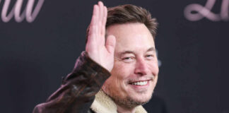Man in leather jacket smiling and waving