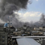Cityscape with smoke rising, buildings, and a mosque.