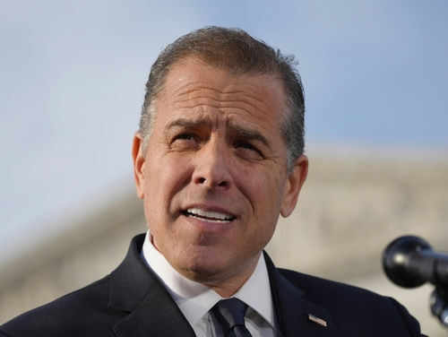 Man in suit speaking outdoors with a microphone