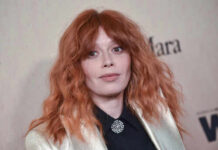 Close-up portrait of a woman with red hair at a fashion event
