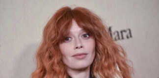 Close-up portrait of a woman with red hair at a fashion event