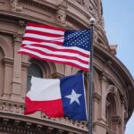 Texas’ No-Nonsense Policy – Immigration Debate Rages American and Texas flags flying in front of a government building