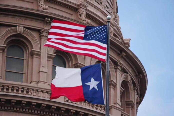shutterstock_2461060809.jpg American and Texas flags flying in front of a government building