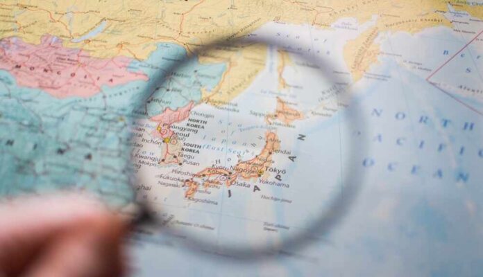 A magnifying glass focusing on a map of Japan