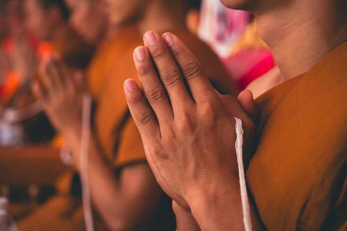 Monks with hands clasped in prayer during a ceremony