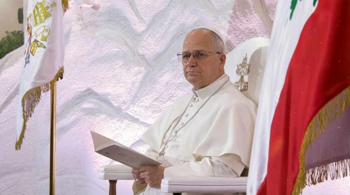 Pope seated in a ceremonial chair with flags in the background