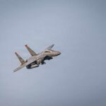 Fighter Jet DOWNED Over Iran – Rescue RACE On A military fighter jet performing an aerial maneuver against a clear sky