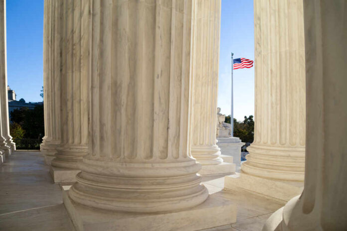 shutterstock_333717620.jpg View of marble columns with an American flag in the background