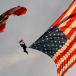 Skydiver SLAMMED Into Scoreboard—20 Minutes of Terror Skydiver descending with a large American flag parachute