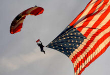 Skydiver descending with a large American flag parachute