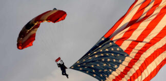Skydiver descending with a large American flag parachute