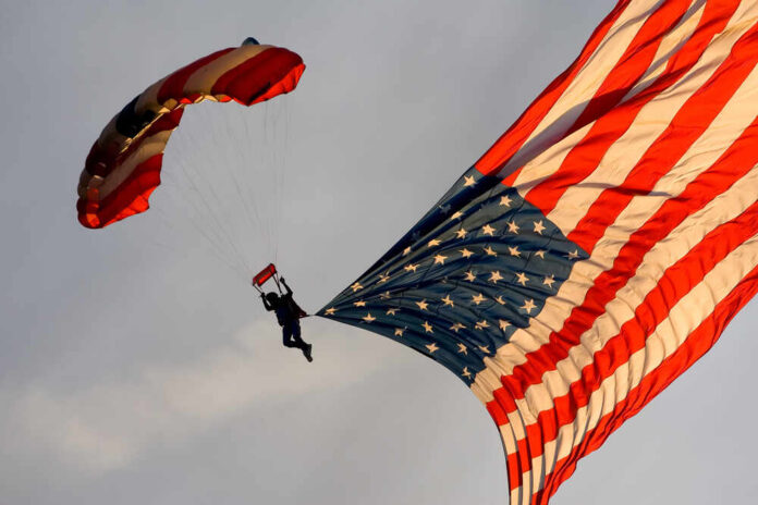 Skydiver descending with a large American flag parachute