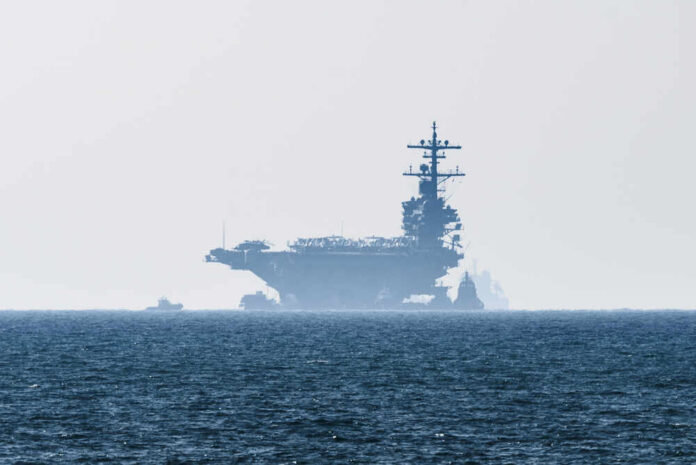 shutterstock_790131061.jpg An aircraft carrier partially obscured by fog on the ocean