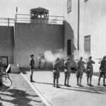 Soldiers executing a prisoner in a military setting