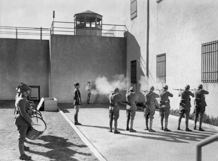 Soldiers executing a prisoner in a military setting