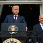 Two men standing at a podium outdoors
