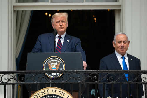 Two men standing at a podium outdoors