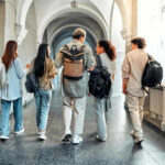 Five students walking in a school hallway together