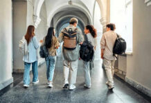 Five students walking in a school hallway together
