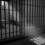 Sunlight streaming through prison cell bars.