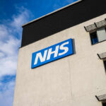 NHS sign on modern hospital building exterior