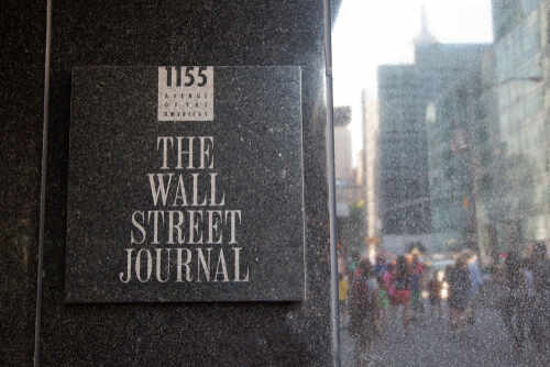 Sign for The Wall Street Journal on a building in a busy city street