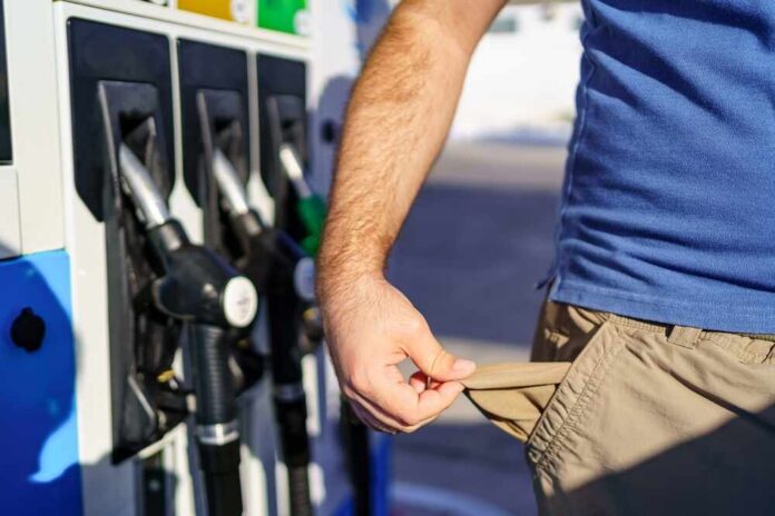 Person showing empty pockets at a gas station