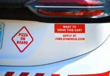 Car with pizza delivery signs and job advertisement
