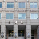 Lawyers in Crosshairs—Asylum Fraud Crackdown US Immigration and Customs Enforcement building entrance flags