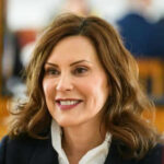 Whitmer Case Shocker — Trial Do-Over Ordered Person smiling indoors with blurred background